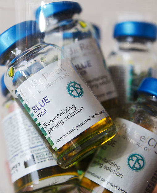 A close-up of vials labeled Blue Face Biorevitalizing Peeling Solution with blue caps.