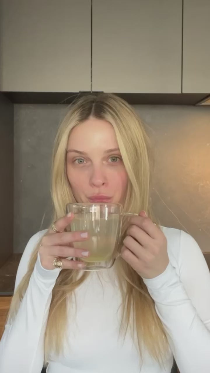 A woman with long blonde hair uses the iS Clinical Active Peel System by iS Clinical in a modern kitchen.